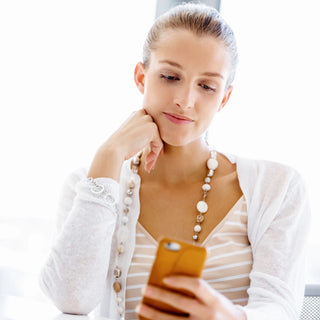 WOMAN LOOKING DOWN AT HER PHONE