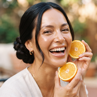 image of a woman holding slices of orange