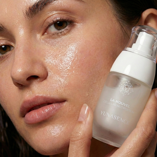 Close-up of a woman holding Lanouvel nutriserum near their face.