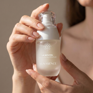 Female hands holding a bottle of Lanouvel serum with a neutral background