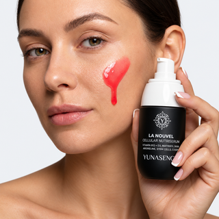 A close-up of a woman holding a black and white pump bottle of YUNASENCE LA NOUVEL Cellular NutriSerum while applying a red serum gel to her cheek.