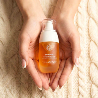 Hand holding a bottle of Yunasence Seleniya against a textured beige background